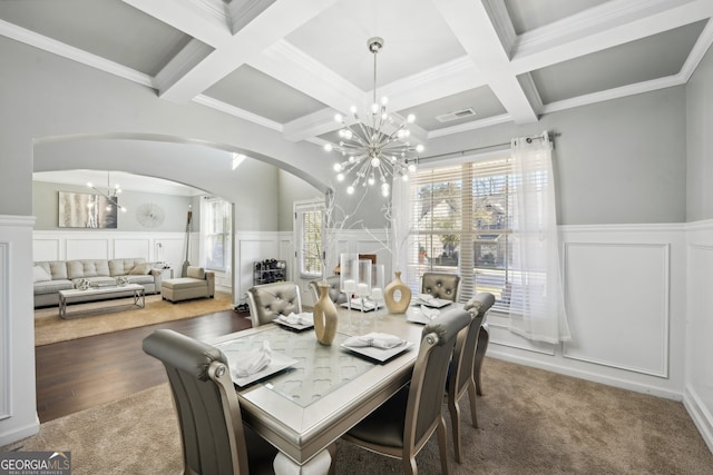 dining area featuring dark hardwood / wood-style flooring, coffered ceiling, crown molding, an inviting chandelier, and beamed ceiling