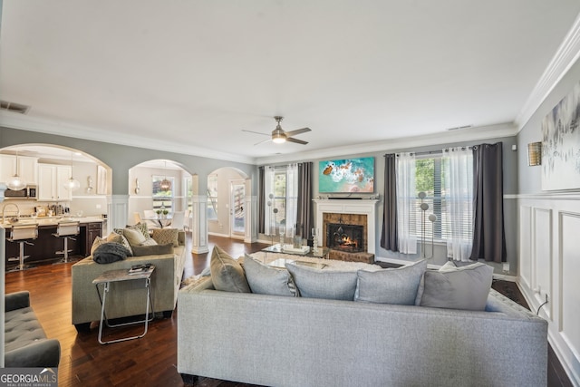 living room featuring dark hardwood / wood-style flooring, crown molding, and a healthy amount of sunlight