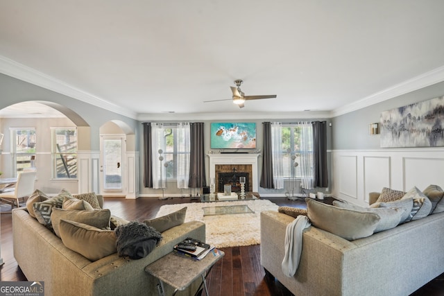 living room with dark hardwood / wood-style flooring, ornamental molding, and a wealth of natural light