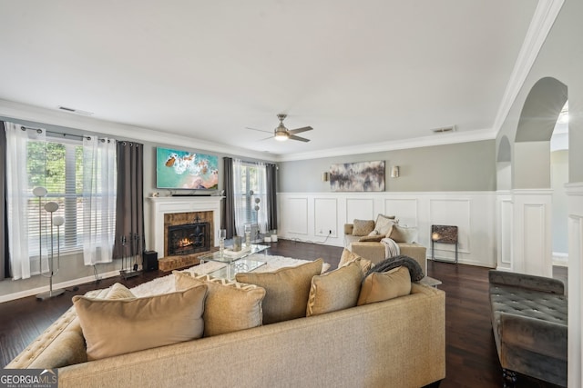 living room featuring a healthy amount of sunlight, ornamental molding, and dark wood-type flooring