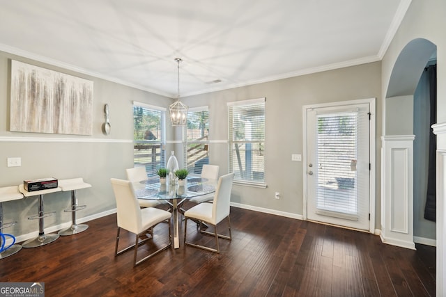 dining room with dark hardwood / wood-style flooring, ornamental molding, and a chandelier