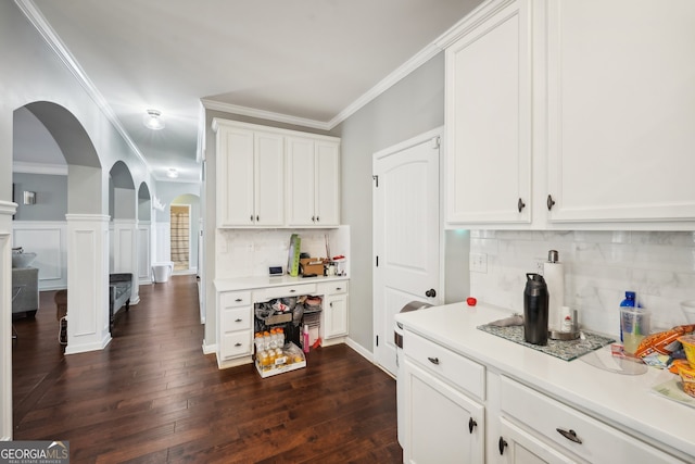 kitchen featuring backsplash, crown molding, dark hardwood / wood-style flooring, and white cabinets