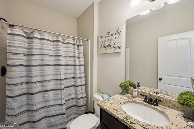 bathroom featuring vanity, toilet, and walk in shower