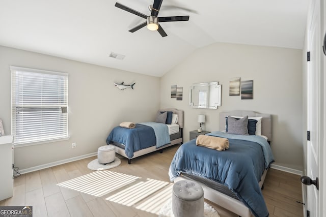 bedroom with ceiling fan, lofted ceiling, and light hardwood / wood-style flooring