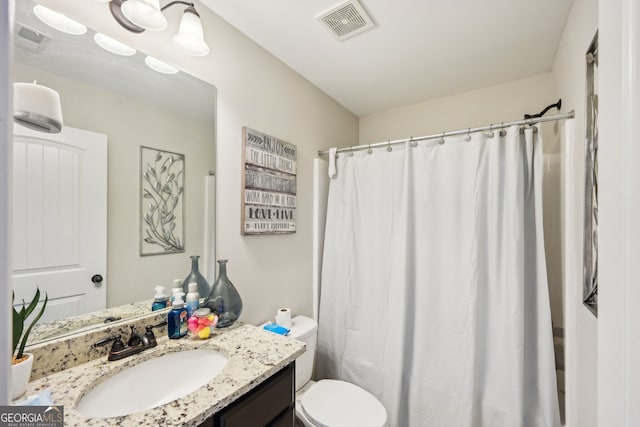 bathroom featuring a shower with shower curtain, vanity, and toilet