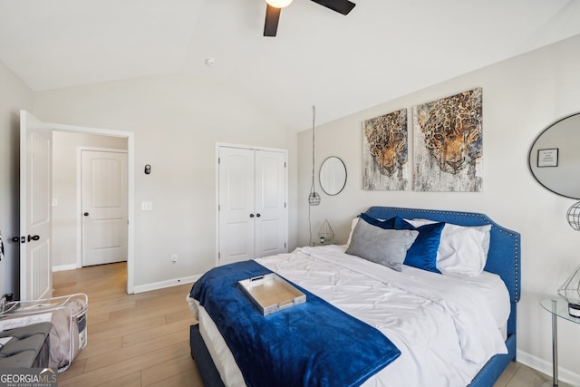 bedroom with ceiling fan, light hardwood / wood-style floors, lofted ceiling, and a closet