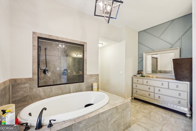 bathroom with tile patterned floors, vanity, and tiled bath