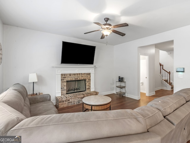 living room featuring hardwood / wood-style floors, a brick fireplace, and ceiling fan