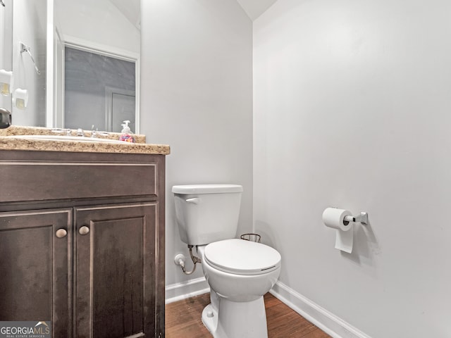 bathroom featuring hardwood / wood-style floors, vanity, toilet, and lofted ceiling