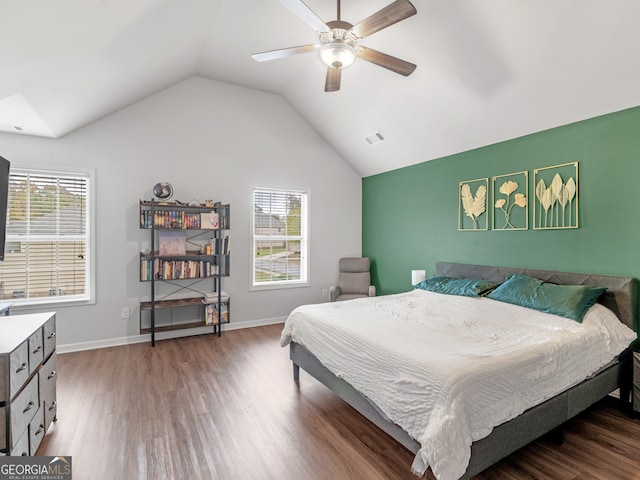 bedroom featuring hardwood / wood-style flooring, ceiling fan, vaulted ceiling, and multiple windows