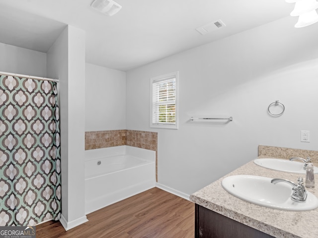 bathroom featuring a bath, wood-type flooring, and vanity