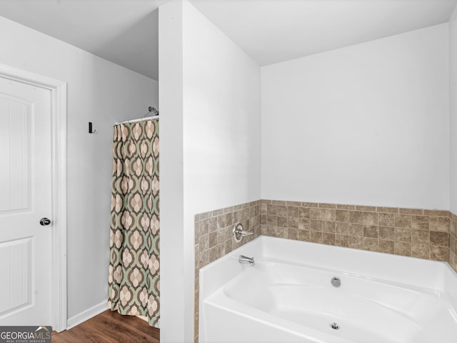 bathroom with hardwood / wood-style flooring and a tub to relax in