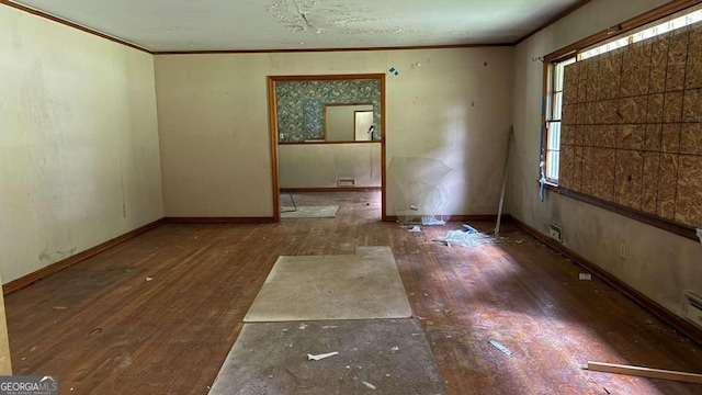 unfurnished room featuring ornamental molding and dark wood-type flooring