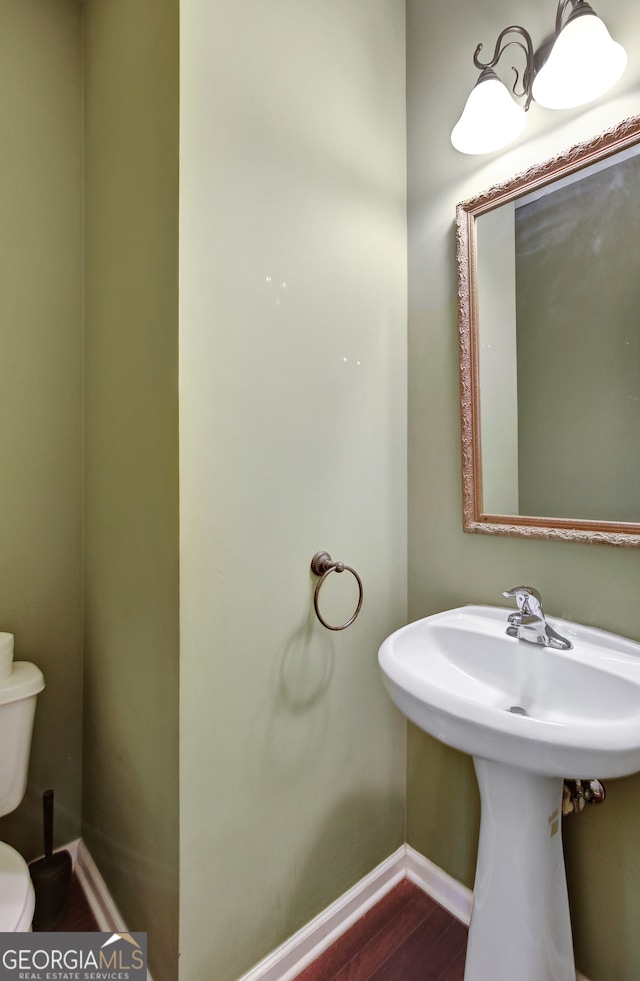 bathroom featuring hardwood / wood-style flooring and toilet