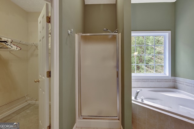 bathroom with shower with separate bathtub and a textured ceiling