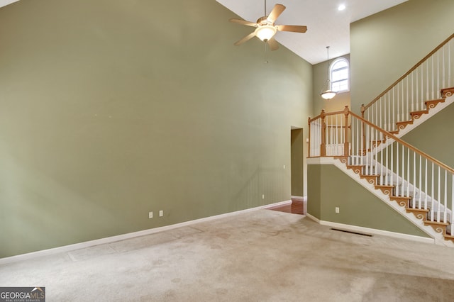 spare room featuring carpet flooring, ceiling fan, and high vaulted ceiling