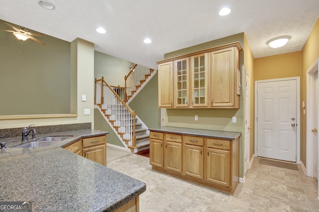 kitchen featuring a textured ceiling, ceiling fan, sink, and light brown cabinetry