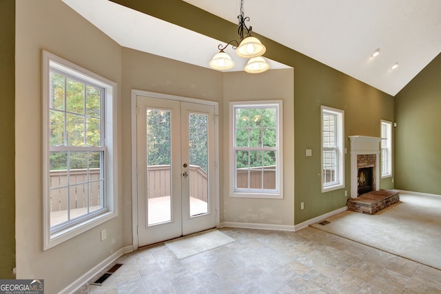 entryway featuring french doors, an inviting chandelier, and vaulted ceiling