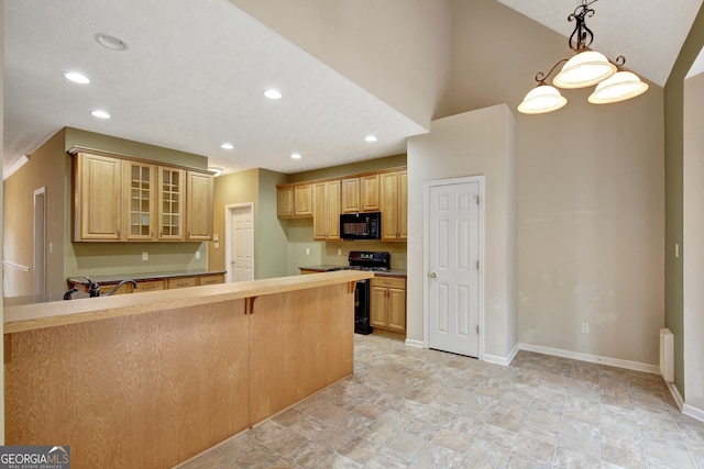 kitchen featuring sink, a kitchen breakfast bar, pendant lighting, lofted ceiling, and black appliances