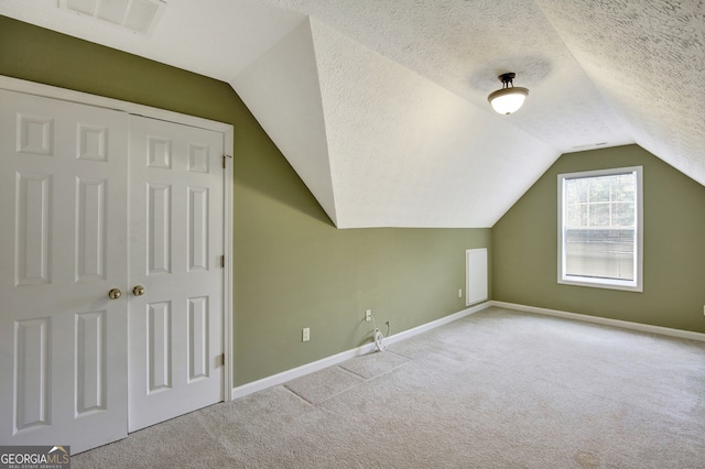 bonus room featuring a textured ceiling, light carpet, and vaulted ceiling