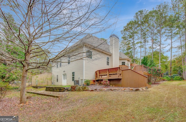 back of house with a lawn and a wooden deck