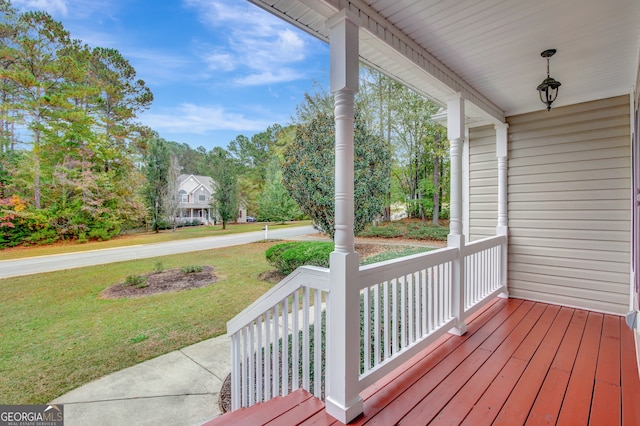 wooden terrace with a porch and a yard