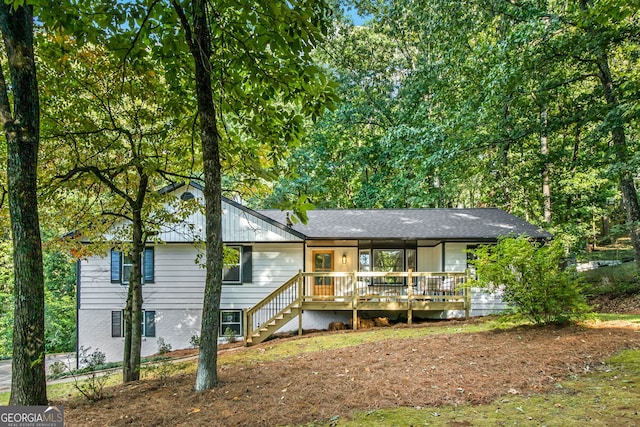 rear view of property featuring a wooden deck