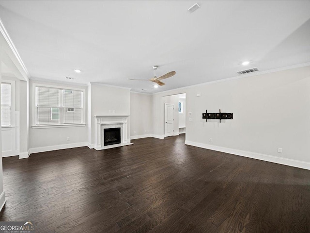 unfurnished living room featuring a high end fireplace, crown molding, ceiling fan, and dark wood-type flooring