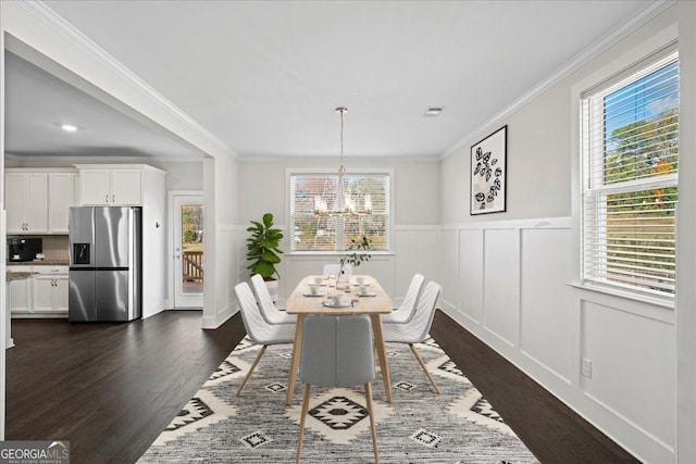 dining room with a chandelier, dark wood-type flooring, and crown molding