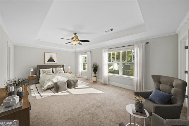 bedroom featuring ceiling fan, crown molding, light carpet, and a tray ceiling