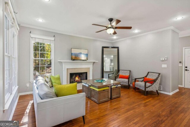 living room featuring hardwood / wood-style flooring, ceiling fan, and ornamental molding