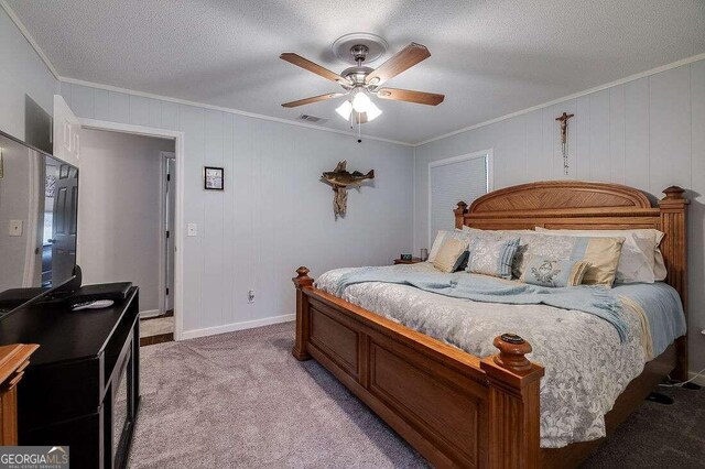 carpeted bedroom featuring ceiling fan, crown molding, wood walls, and a textured ceiling