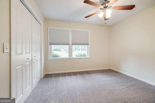 unfurnished bedroom with ceiling fan, a closet, carpet, and a textured ceiling