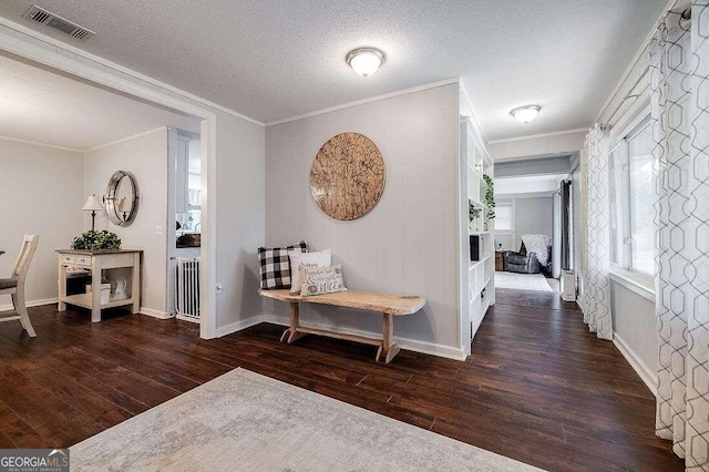 hallway with a textured ceiling, crown molding, and dark hardwood / wood-style floors