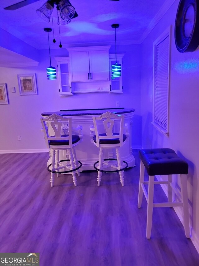 bar featuring white cabinets, hardwood / wood-style floors, decorative light fixtures, and ornamental molding