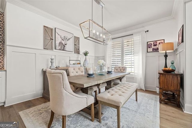 dining area featuring crown molding, hardwood / wood-style floors, and an inviting chandelier