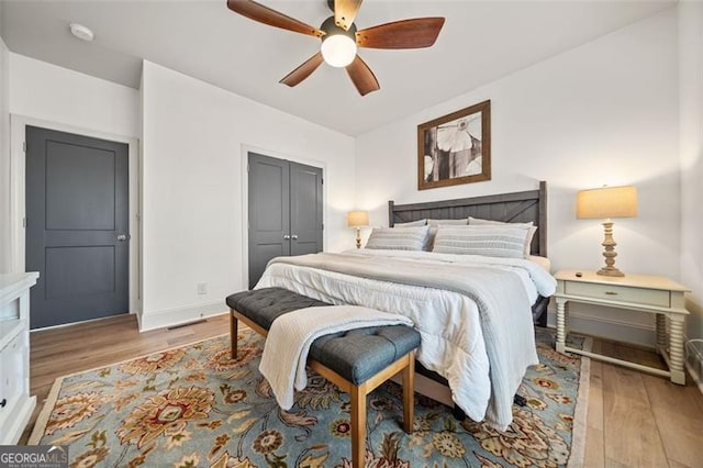 bedroom with ceiling fan, a closet, and light hardwood / wood-style floors