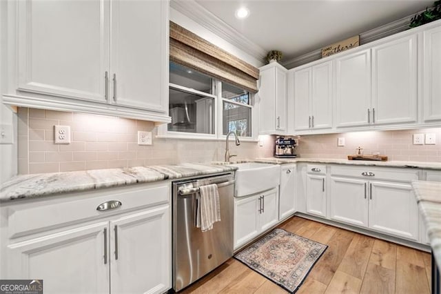 kitchen featuring light stone countertops, stainless steel dishwasher, sink, light hardwood / wood-style flooring, and white cabinetry