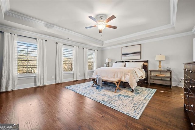 bedroom with ceiling fan, a raised ceiling, and multiple windows