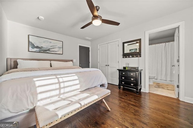 bedroom featuring a closet, dark hardwood / wood-style floors, ensuite bath, and ceiling fan