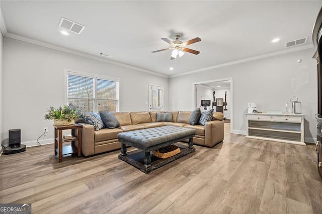 living room featuring light hardwood / wood-style floors, ceiling fan, and ornamental molding