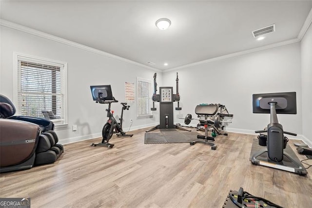 workout room with light hardwood / wood-style flooring and crown molding