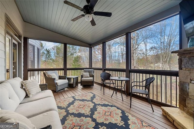 sunroom / solarium with ceiling fan, wooden ceiling, and vaulted ceiling