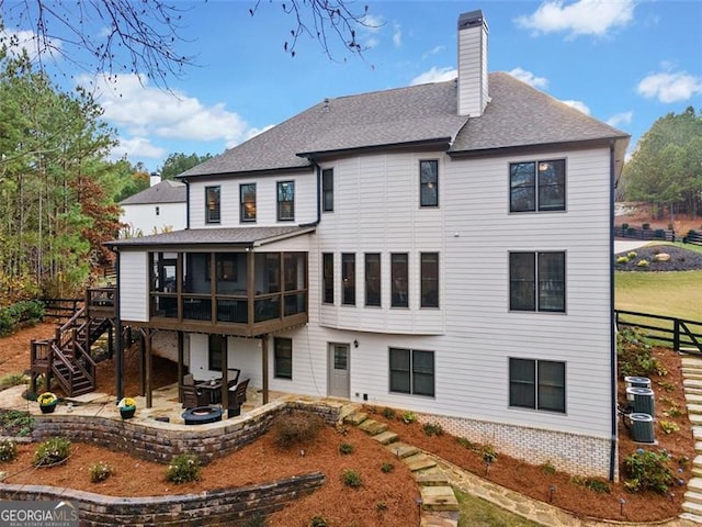 rear view of property with a sunroom and a patio area