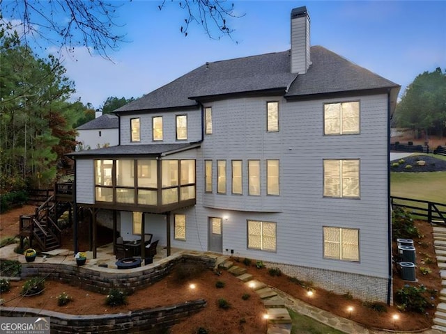 back house at dusk featuring a patio area