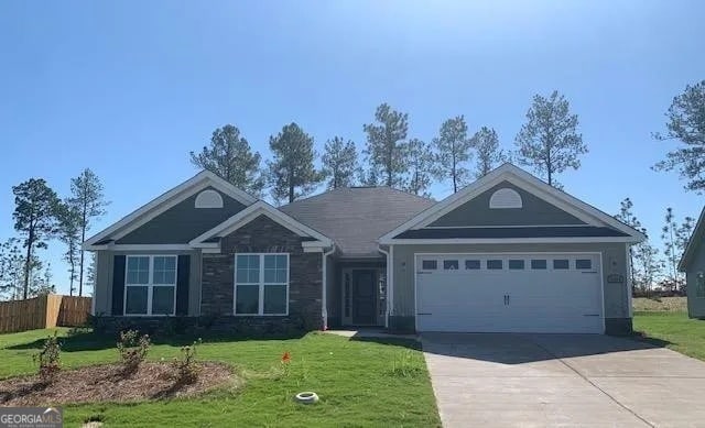 view of front of home featuring a front yard and a garage