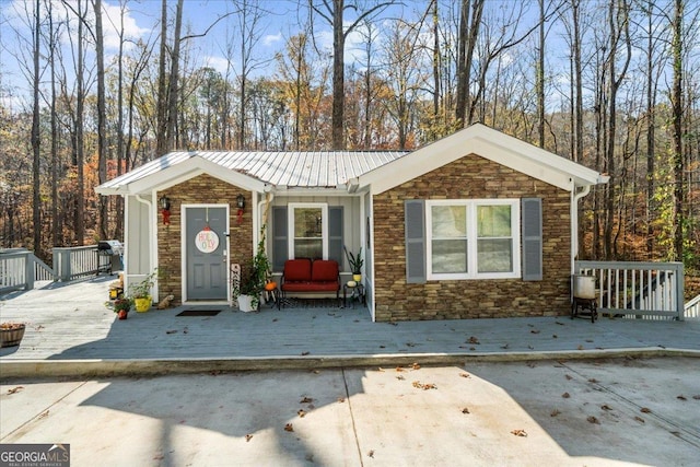 173 Mountainside Dr E, Dawsonville, GA 30534 - view of front of property with stone siding, a deck, and metal roof