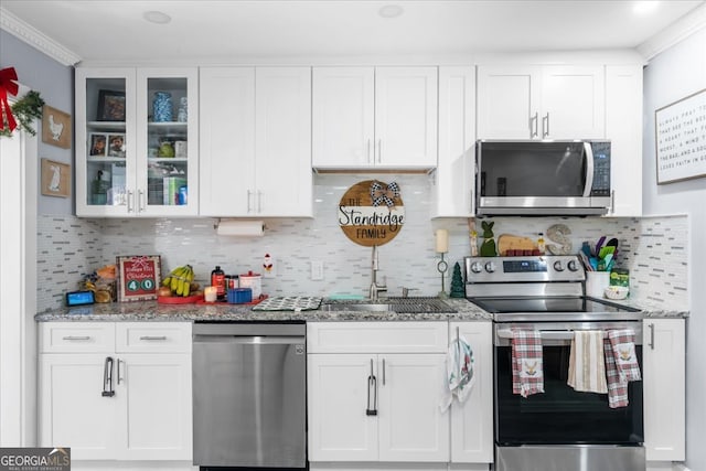 kitchen featuring light stone counters, sink, white cabinets, and appliances with stainless steel finishes