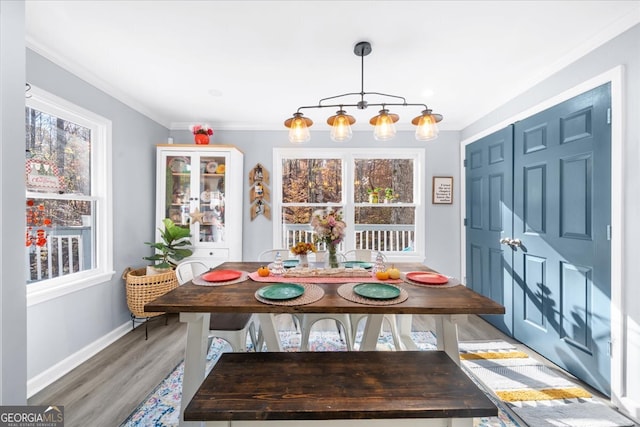 dining area featuring hardwood / wood-style floors, a notable chandelier, and crown molding