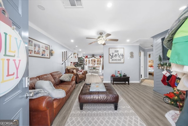 living room featuring light wood-type flooring, ceiling fan, and crown molding